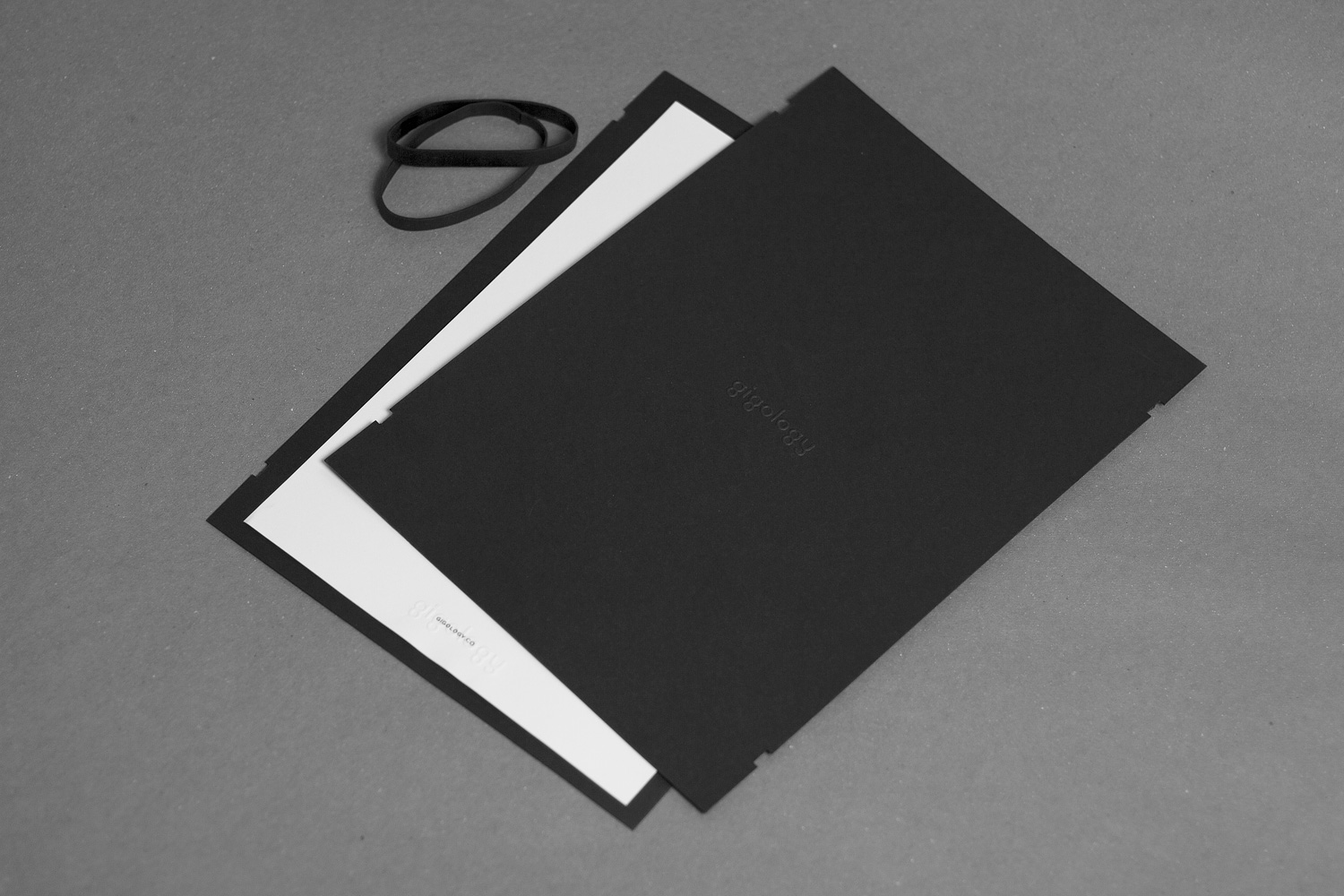 Gigology monochrome identity applied across printed material