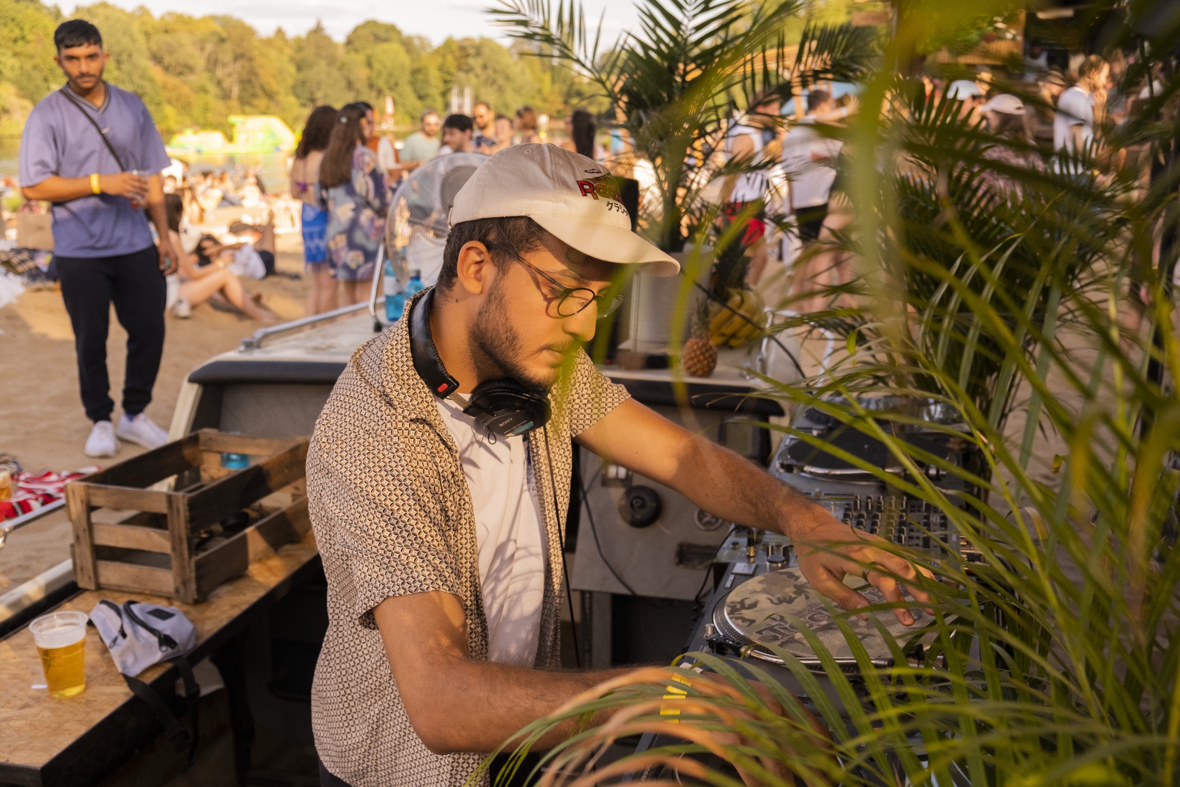SUNDAZE selector performing among palms beside the lake