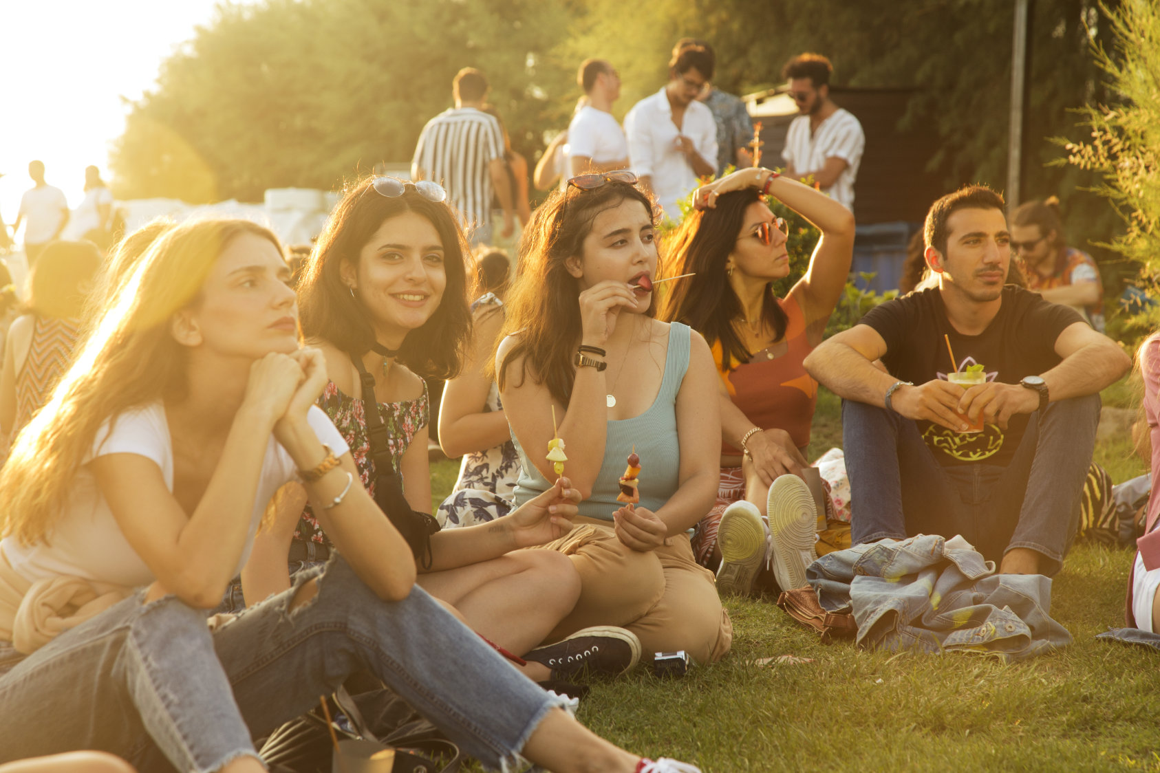 Friends sharing fruit together at SUNDAZE in the evening light